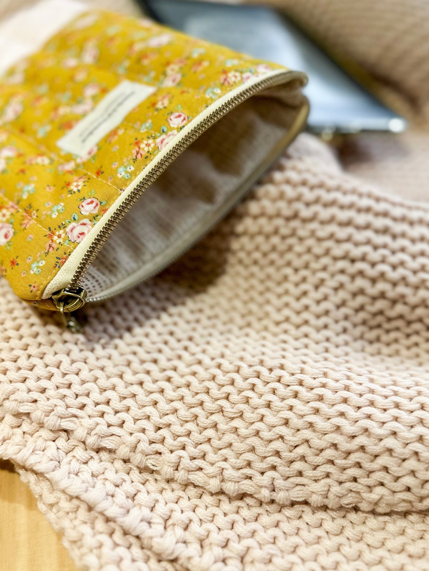 Floral-patterned pouch on a textured beige surface