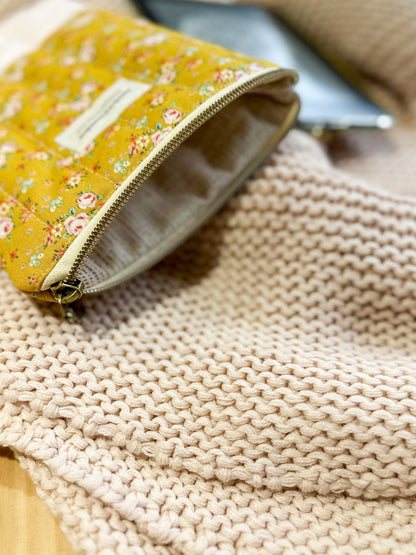 Floral-patterned pouch on a textured beige surface