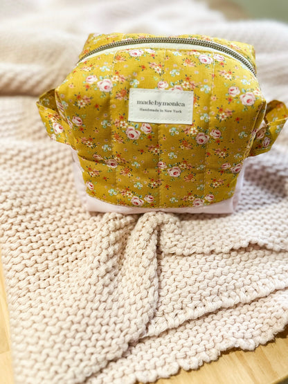 Floral-patterned bag with 'made by menina' label on a textured surface