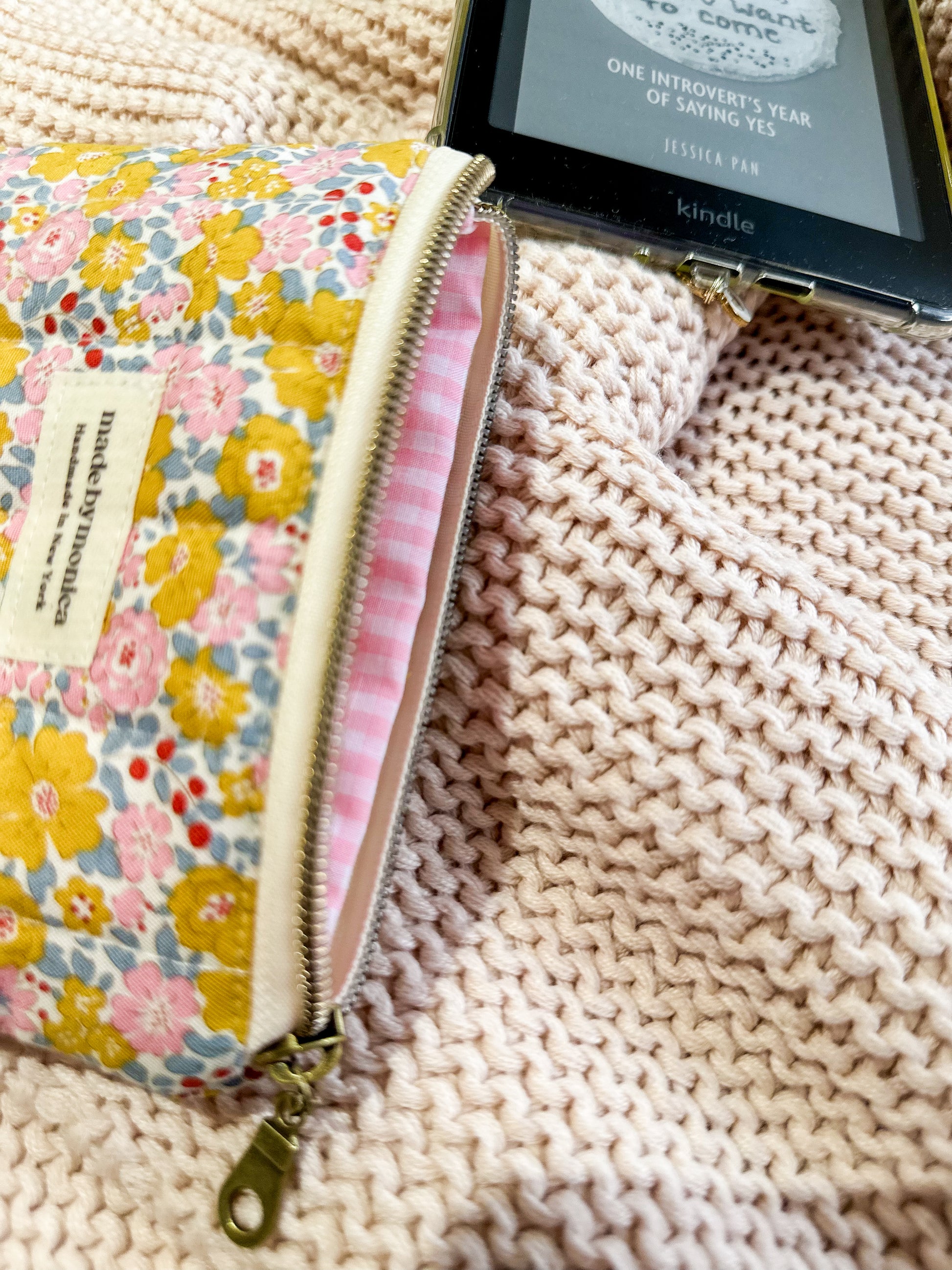 Floral-patterned pouch with a Kindle device on a textured surface