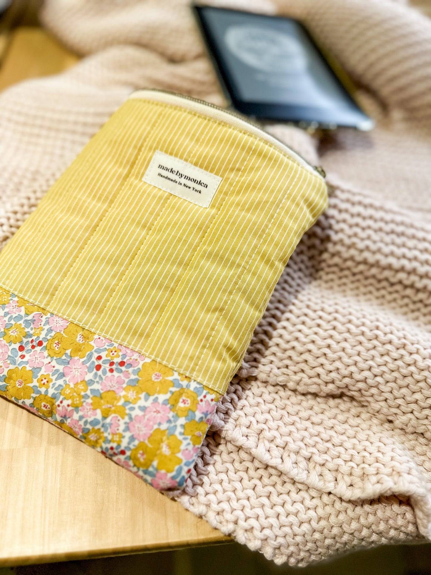 Yellow fabric pouch with floral pattern on a textured surface