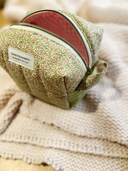 Floral-patterned pouch with a zipper on a textured fabric background