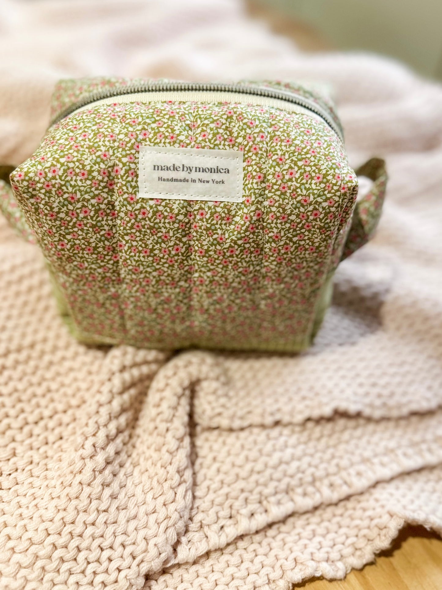 Small fabric pouch with floral pattern on a textured surface
