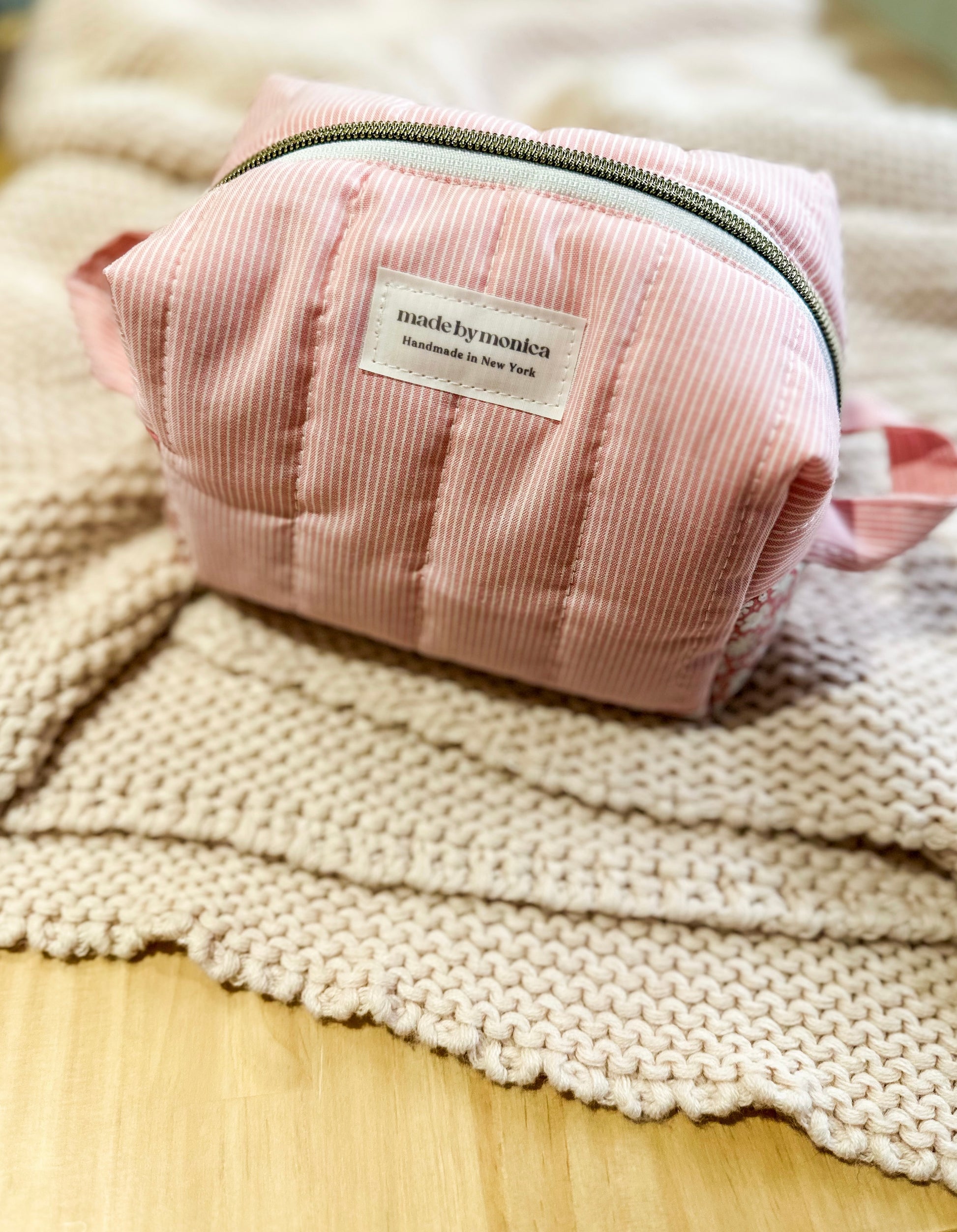 Pink pouch with a label on a textured surface